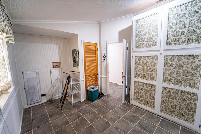 bathroom featuring a textured ceiling, ornamental molding, vaulted ceiling, and tile patterned flooring