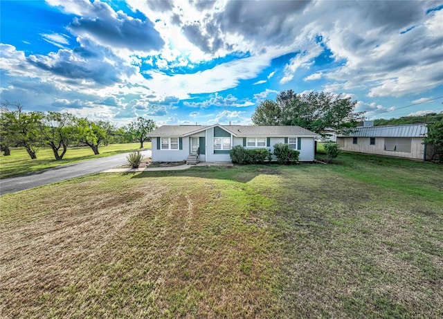 ranch-style house featuring aphalt driveway and a front yard