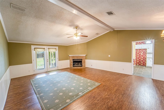 unfurnished living room with a wainscoted wall and visible vents