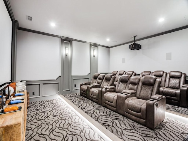 carpeted home theater room with recessed lighting, visible vents, crown molding, and a decorative wall