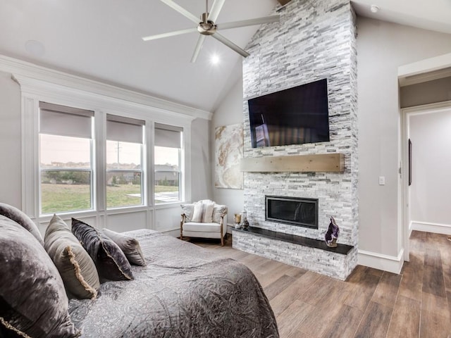 bedroom with ceiling fan, high vaulted ceiling, a fireplace, wood finished floors, and baseboards