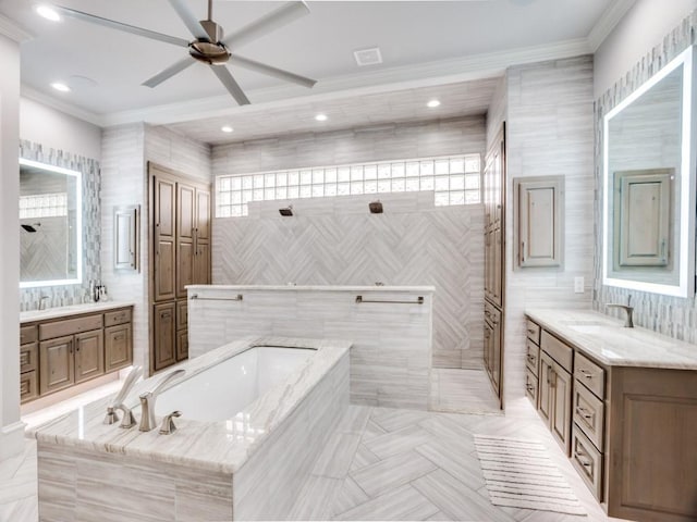 bathroom featuring a bath, ornamental molding, two vanities, and a sink