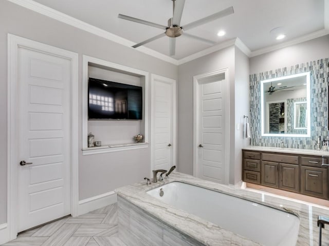 full bath featuring ceiling fan, a garden tub, recessed lighting, vanity, and ornamental molding