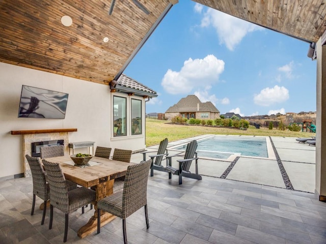 outdoor pool with outdoor dining area and a patio