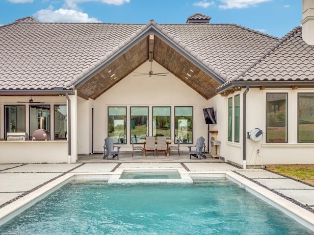 back of house with a tiled roof, a patio, and stucco siding