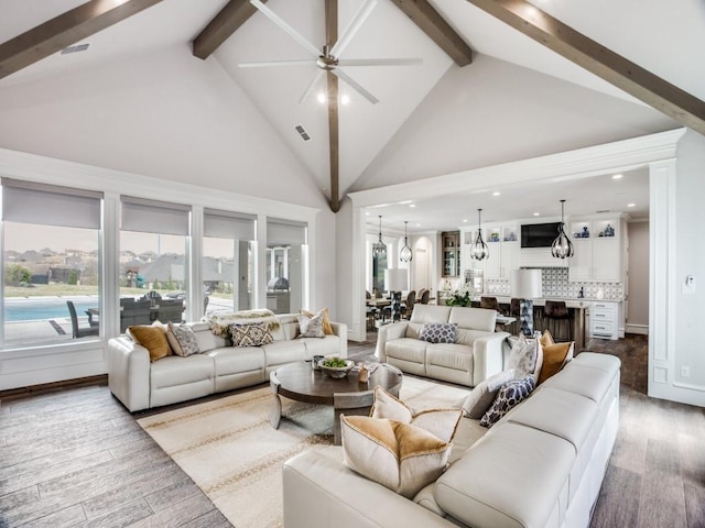 living room with high vaulted ceiling, beamed ceiling, wood finished floors, and visible vents