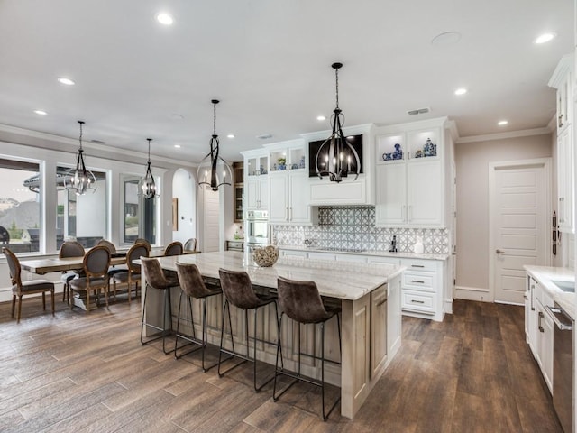 kitchen with visible vents, dark wood-style floors, tasteful backsplash, glass insert cabinets, and an inviting chandelier