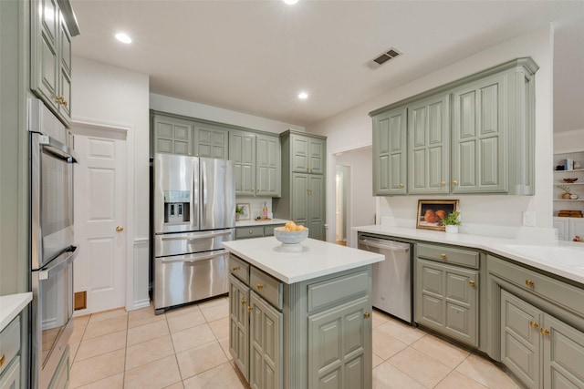 kitchen with light tile patterned floors, visible vents, stainless steel appliances, and green cabinetry