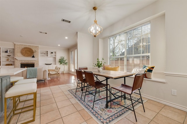 dining space featuring built in shelves, visible vents, a fireplace, and light tile patterned flooring