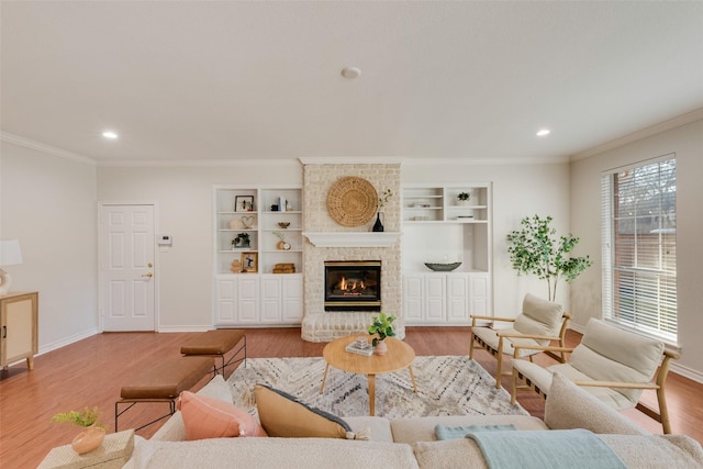 living area with ornamental molding, a fireplace, wood finished floors, and baseboards