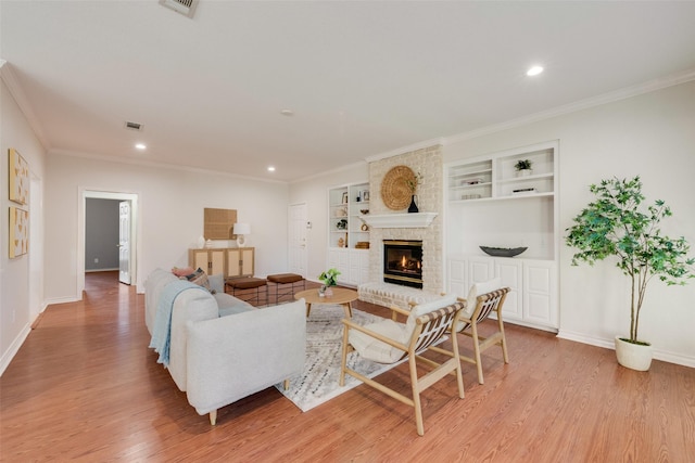 living room with light wood-style floors, visible vents, ornamental molding, and baseboards