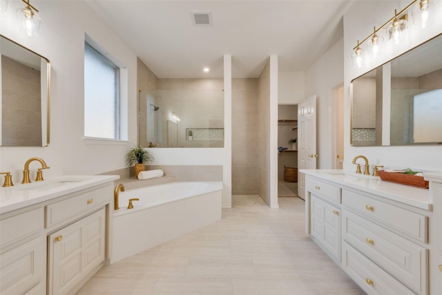 bathroom with two vanities, visible vents, walk in shower, and a sink