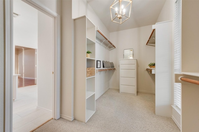 walk in closet featuring light carpet, visible vents, and an inviting chandelier