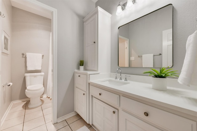 bathroom featuring tile patterned flooring, baseboards, vanity, and toilet