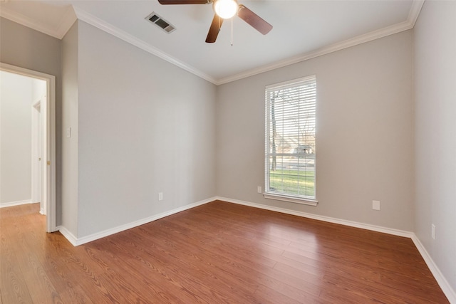 unfurnished room featuring visible vents, crown molding, baseboards, and wood finished floors