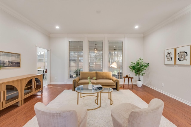 living area featuring baseboards, recessed lighting, wood finished floors, and crown molding