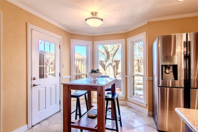 dining room with light tile patterned flooring, crown molding, and baseboards