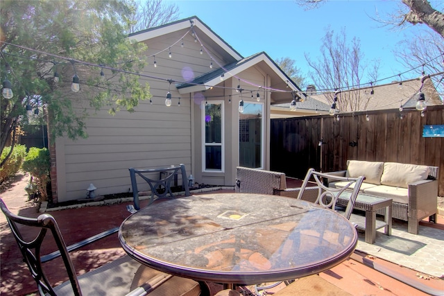 view of patio with outdoor dining area, fence, and an outdoor living space