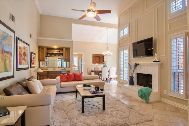 living area featuring a towering ceiling, light tile patterned floors, visible vents, and ornamental molding