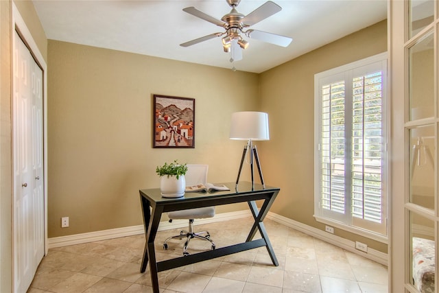 office area with a ceiling fan, baseboards, and light tile patterned floors