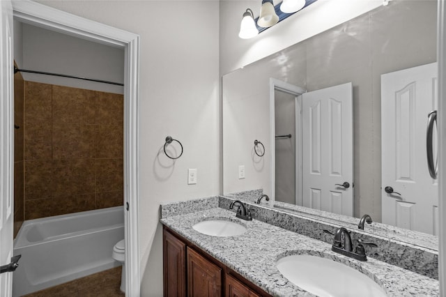 bathroom with a sink, shower / bathing tub combination, toilet, and double vanity