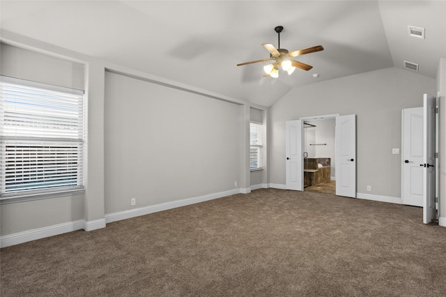 unfurnished bedroom featuring connected bathroom, carpet, visible vents, and vaulted ceiling