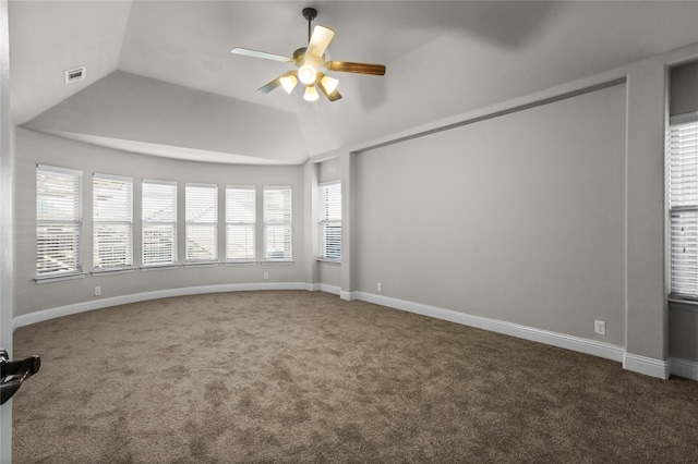 carpeted spare room featuring ceiling fan, visible vents, baseboards, and vaulted ceiling