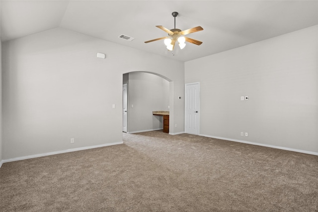 spare room featuring arched walkways, lofted ceiling, visible vents, a ceiling fan, and light carpet