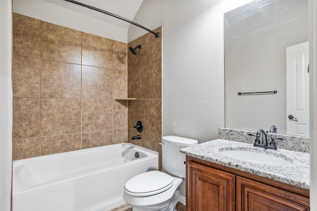 bathroom featuring a textured wall, shower / tub combination, vanity, and toilet