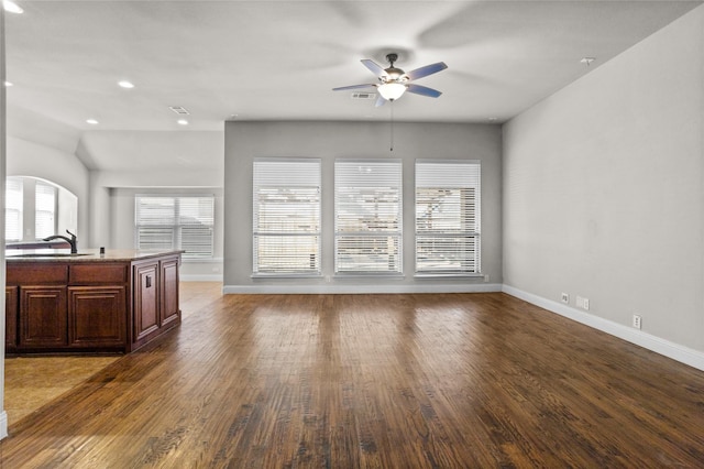 unfurnished living room with baseboards, ceiling fan, wood finished floors, a sink, and recessed lighting