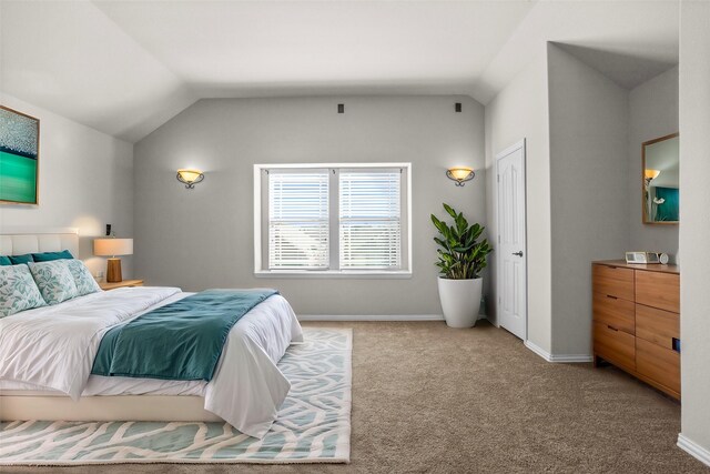 carpeted bedroom featuring baseboards and vaulted ceiling