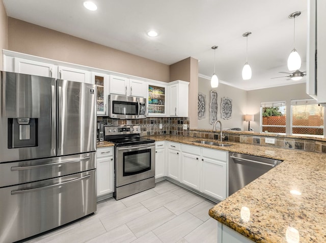 kitchen featuring stainless steel appliances, white cabinetry, a sink, and backsplash