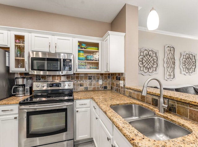 kitchen featuring glass insert cabinets, appliances with stainless steel finishes, a sink, white cabinetry, and backsplash