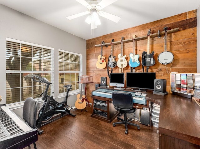 office featuring ceiling fan, wood finished floors, and wooden walls