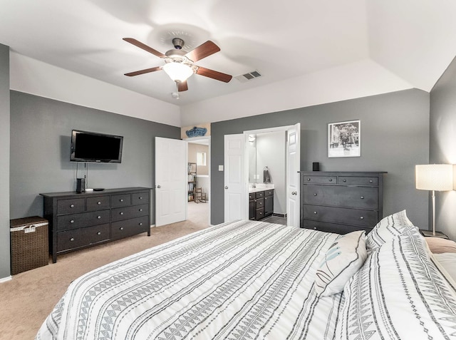 carpeted bedroom with a ceiling fan, visible vents, vaulted ceiling, and connected bathroom