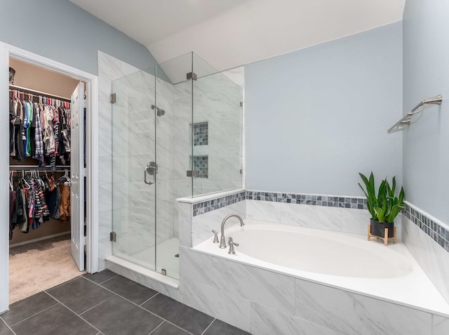 full bathroom with a walk in closet, tile patterned flooring, a garden tub, and a shower stall