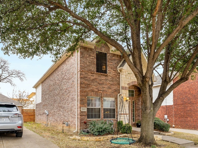 view of front of house featuring fence and brick siding