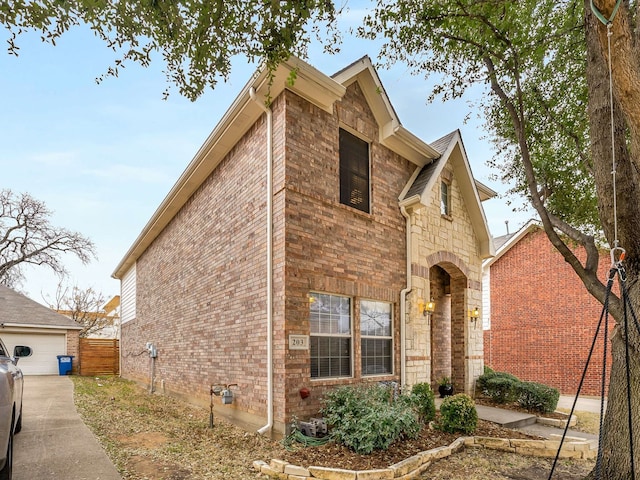 view of side of property with stone siding, brick siding, and fence