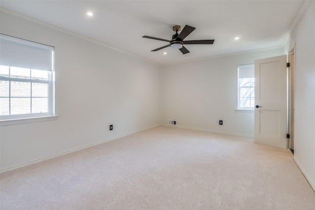 unfurnished room with a wealth of natural light, light colored carpet, and crown molding