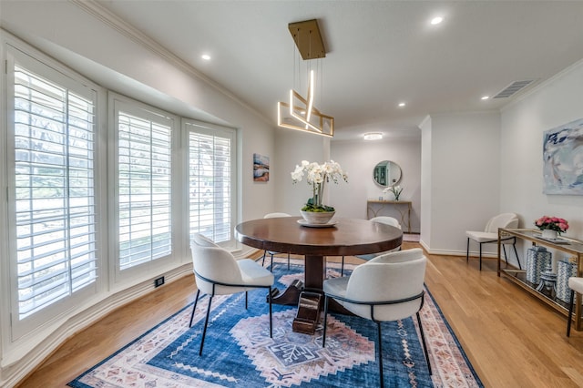 dining space with light wood-type flooring, recessed lighting, visible vents, and ornamental molding