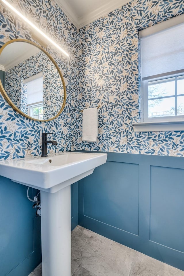 bathroom featuring ornamental molding and wallpapered walls