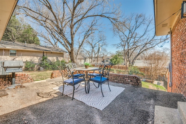 view of patio / terrace featuring a fenced backyard, a grill, and outdoor dining space