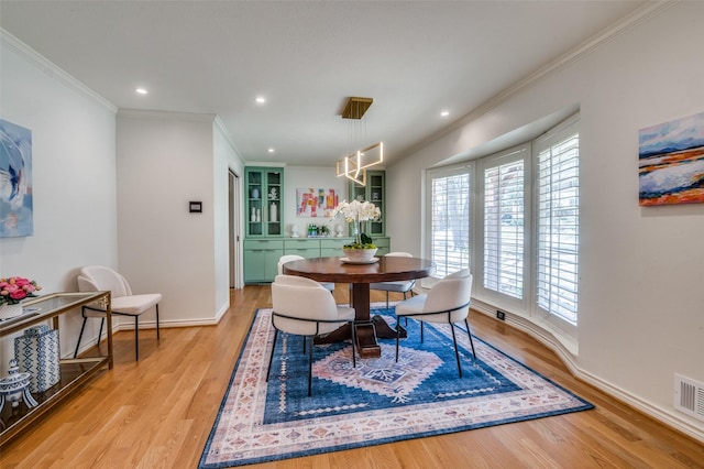 dining space with recessed lighting, wood finished floors, visible vents, baseboards, and crown molding