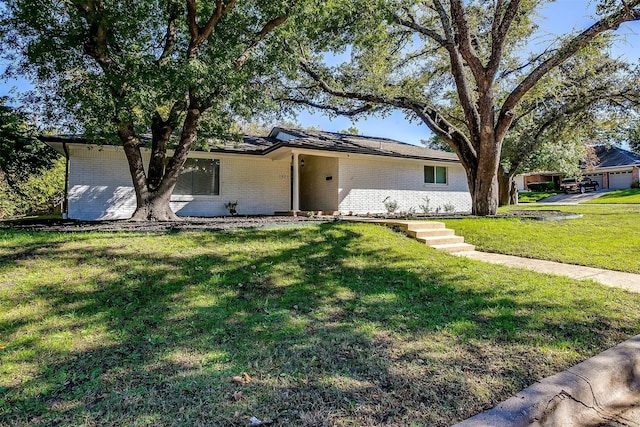 single story home with a front yard and brick siding