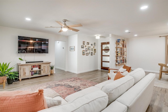 living area with baseboards, light wood-style flooring, and recessed lighting