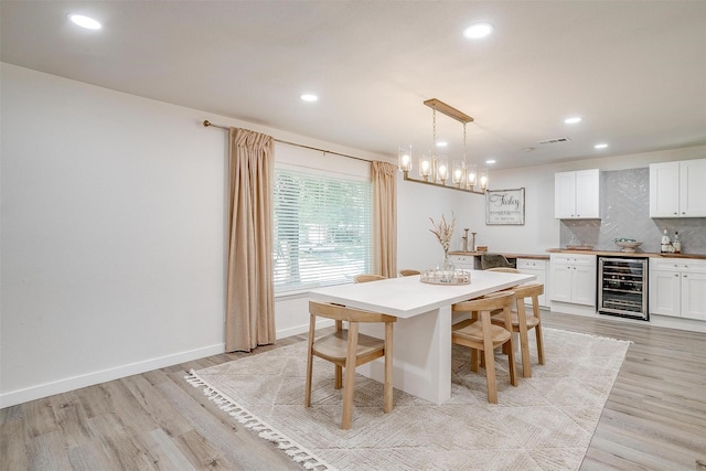 dining space featuring light wood finished floors, baseboards, visible vents, wine cooler, and recessed lighting