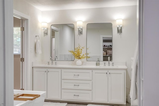 bathroom featuring a sink and double vanity