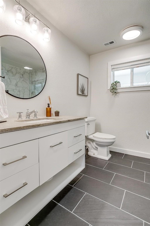 full bathroom featuring visible vents, toilet, tile patterned floors, a textured ceiling, and vanity