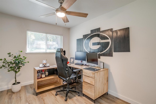 home office with baseboards, ceiling fan, and light wood finished floors