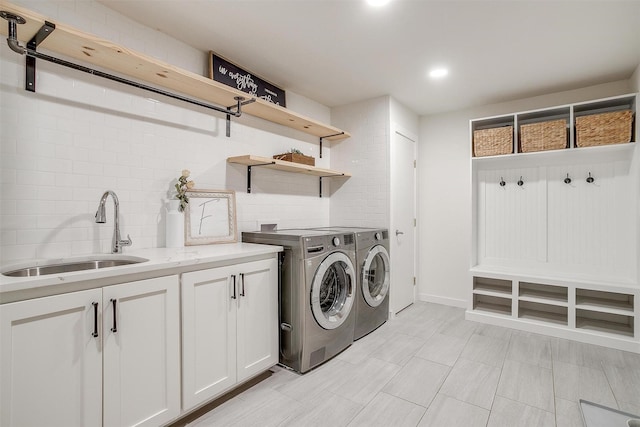 washroom with recessed lighting, cabinet space, a sink, and washing machine and clothes dryer